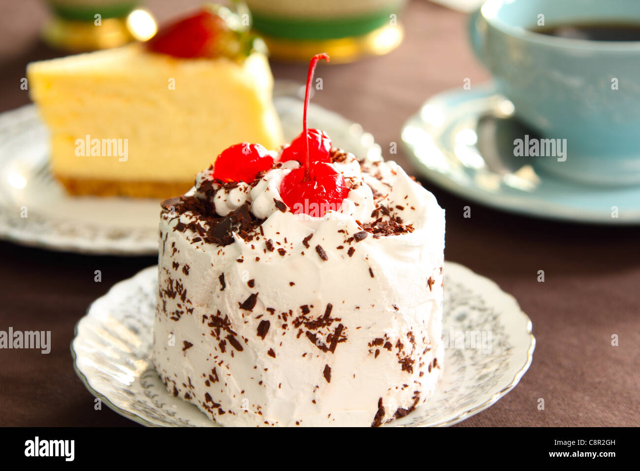 La torta di panna con la ciliegia sulla parte superiore Foto Stock