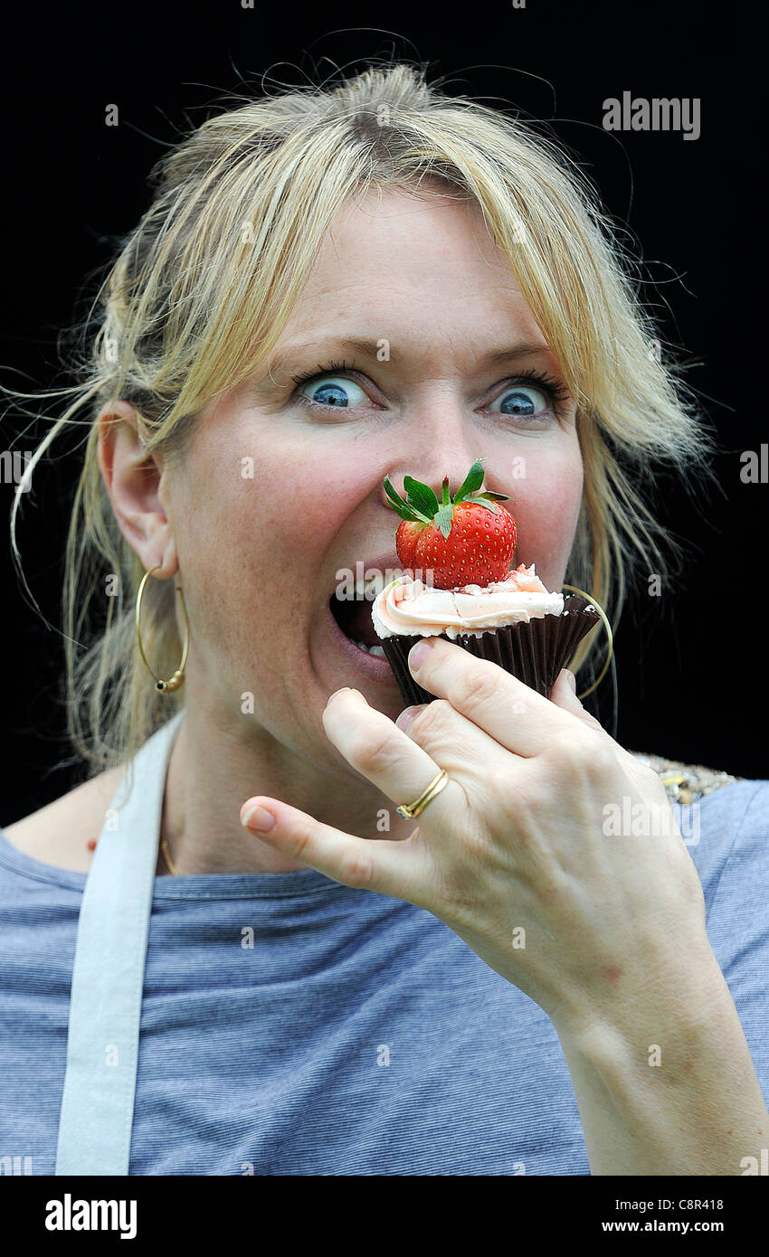 Celebrity Chef e il libro di ricette autore Rachel Allen foto di mangiare una tortina contro uno sfondo nero. Foto Stock