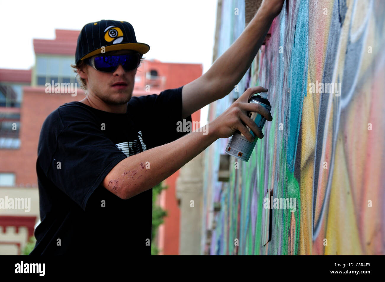 Artista il design di spruzzatura su un muro di mattoni di edificio in 'Freak Alley' Foto Stock