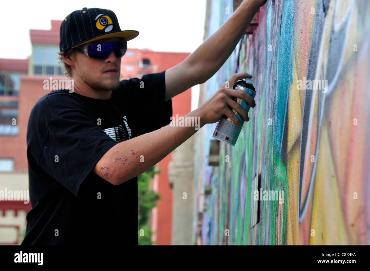 Artista il design di spruzzatura su un muro di mattoni di edificio in 'Freak Alley' Foto Stock