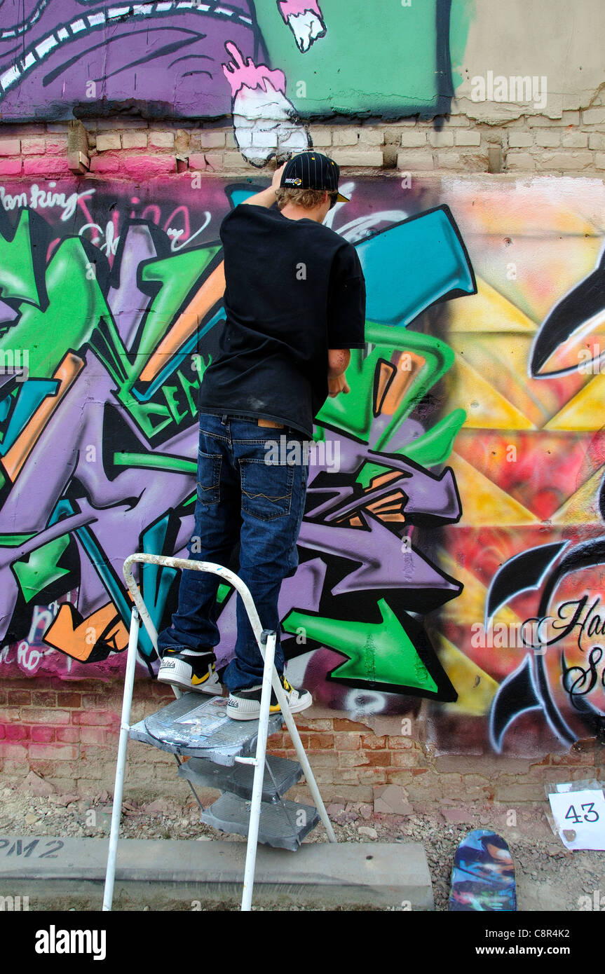 Artista il design di spruzzatura su un muro di mattoni di edificio in 'Freak Alley' Foto Stock