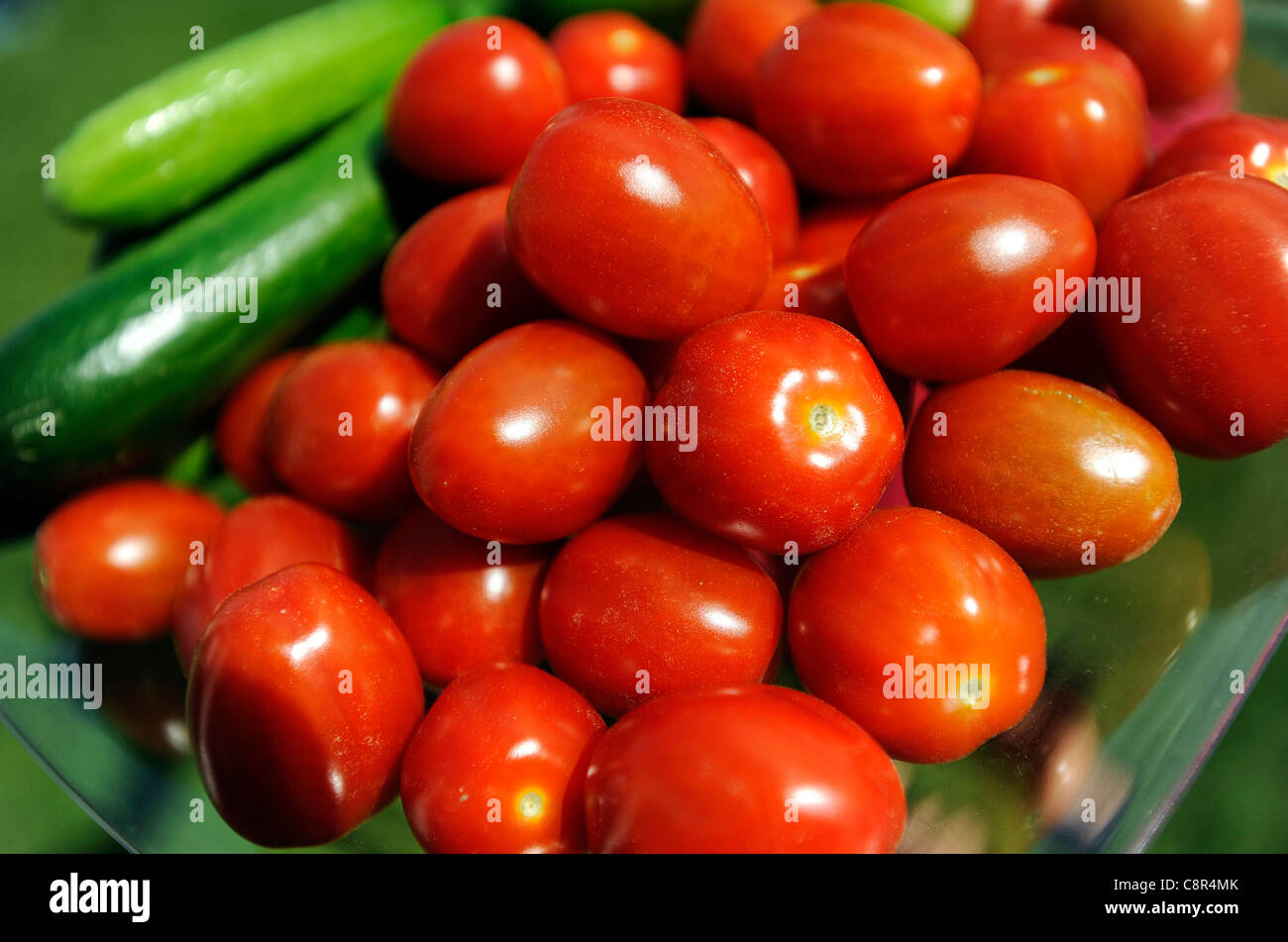 Organici di pomodori ciliegia e il cetriolo visualizzato in un cestello. Foto Stock