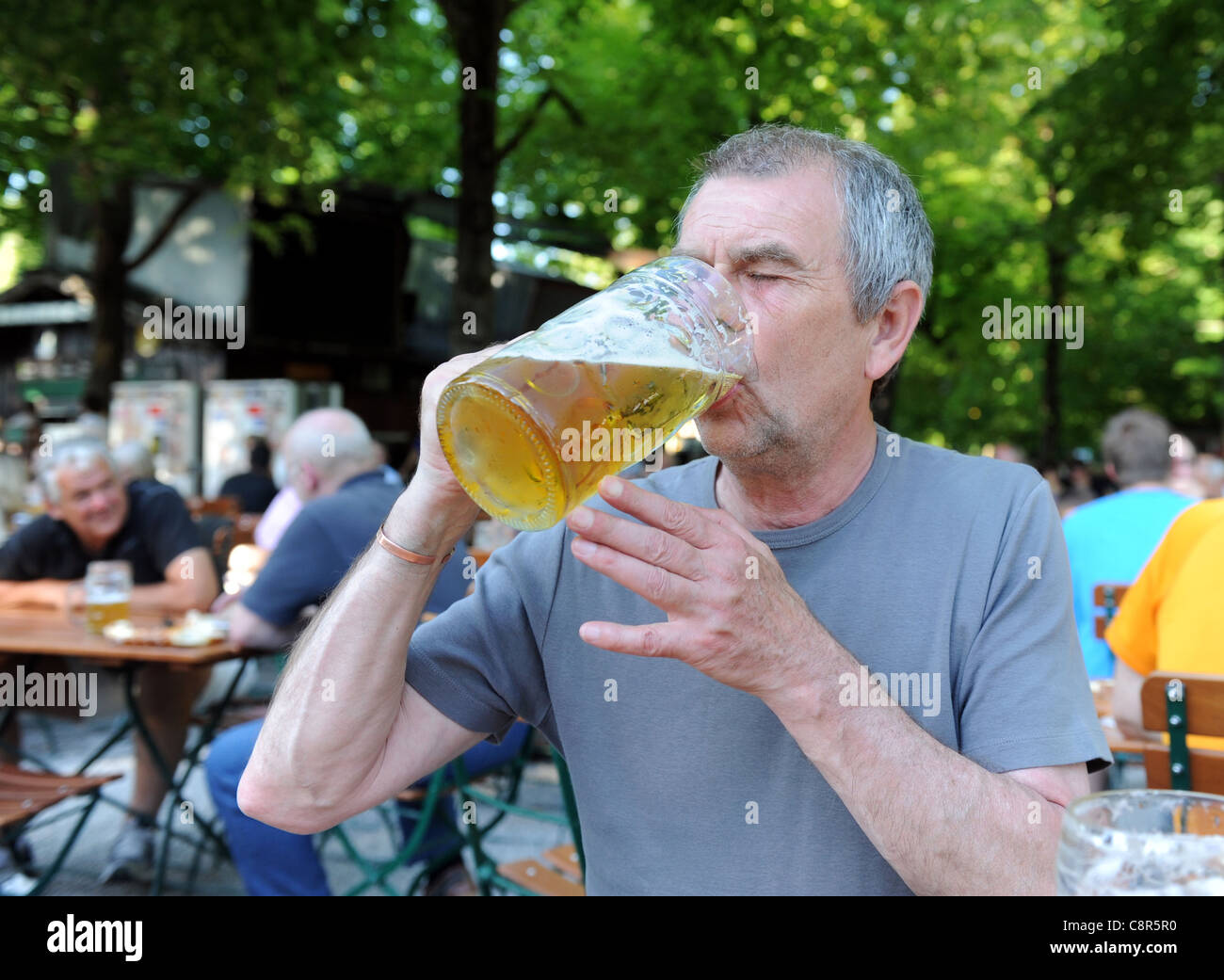 Uomo che beve birra tedesca all'Hirschgarten di Monaco di Baviera Germania Munchen Deutschland Foto Stock