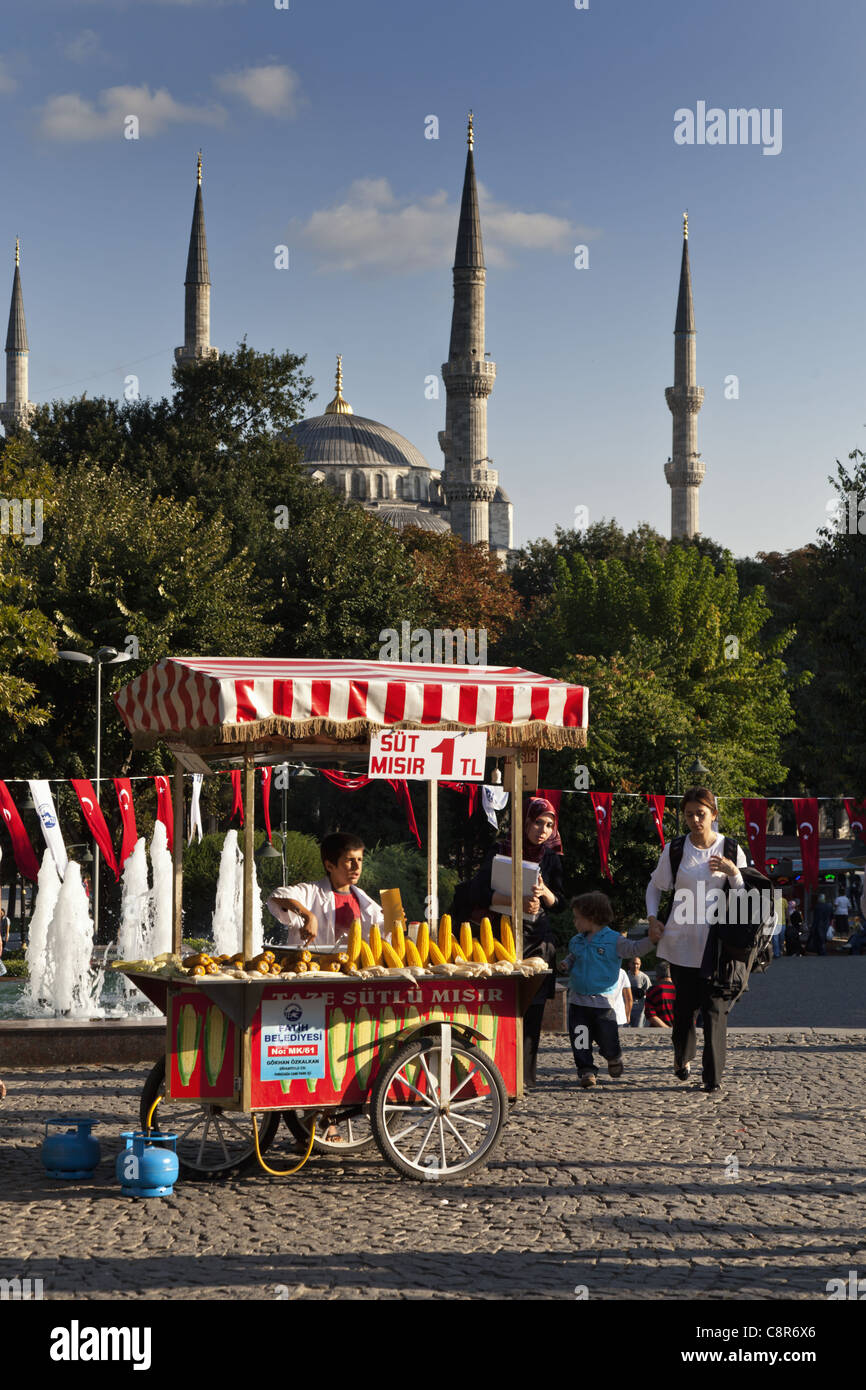 Ragazzo di vendita di tutoli di mais di fronte la Moschea Blu, Istanbul, Turchia Moschee Foto Stock