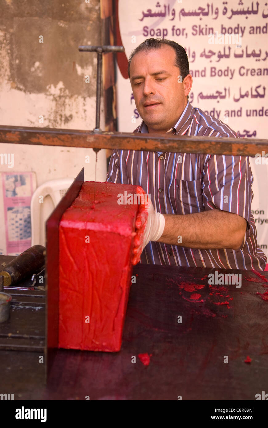 Creatore di sapone sapone di taglio di forma in preparazione per la vendita, souk, Tripoli, nel nord del Libano. Foto Stock