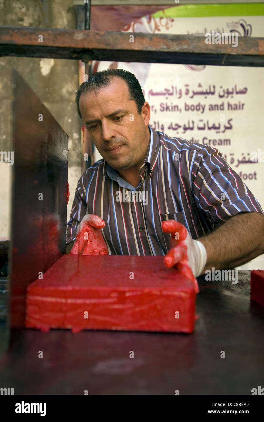 Creatore di sapone sapone di taglio di forma in preparazione per la vendita, souk, Tripoli, nel nord del Libano. Foto Stock