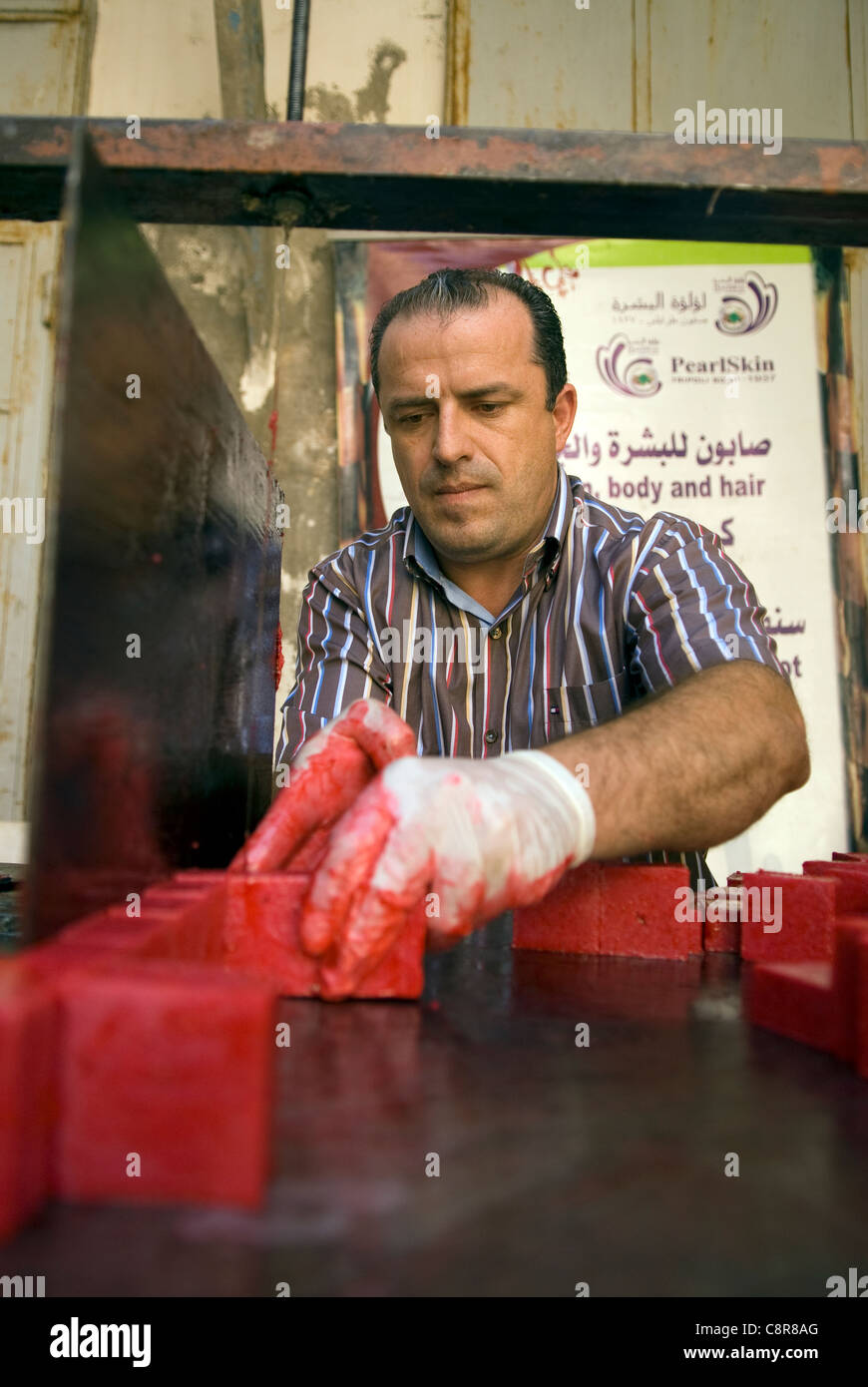 Creatore di sapone sapone di taglio di forma in preparazione per la vendita, souk, Tripoli, nel nord del Libano. Foto Stock