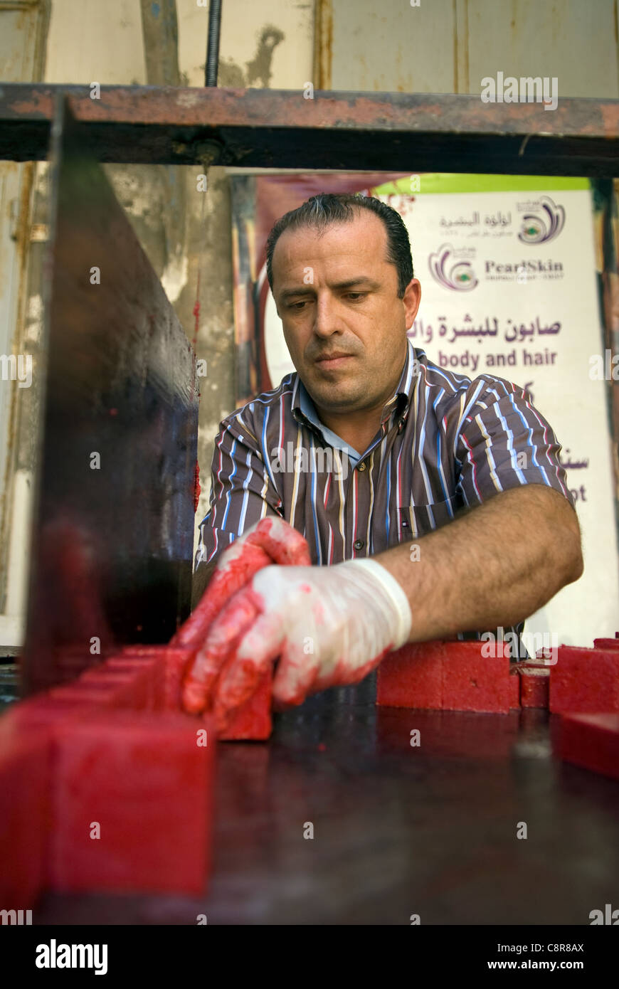 Creatore di sapone sapone di taglio di forma in preparazione per la vendita, souk, Tripoli, nel nord del Libano. Foto Stock