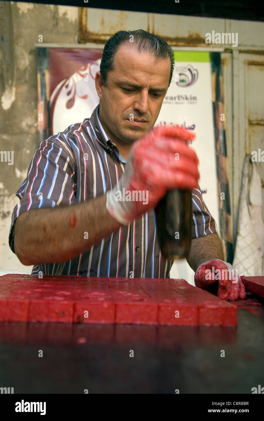 Creatore di sapone sapone di stampaggio con il Libano è emblema nazionale, il cedro, in preparazione per la vendita, souk, Tripoli, Libano. Foto Stock