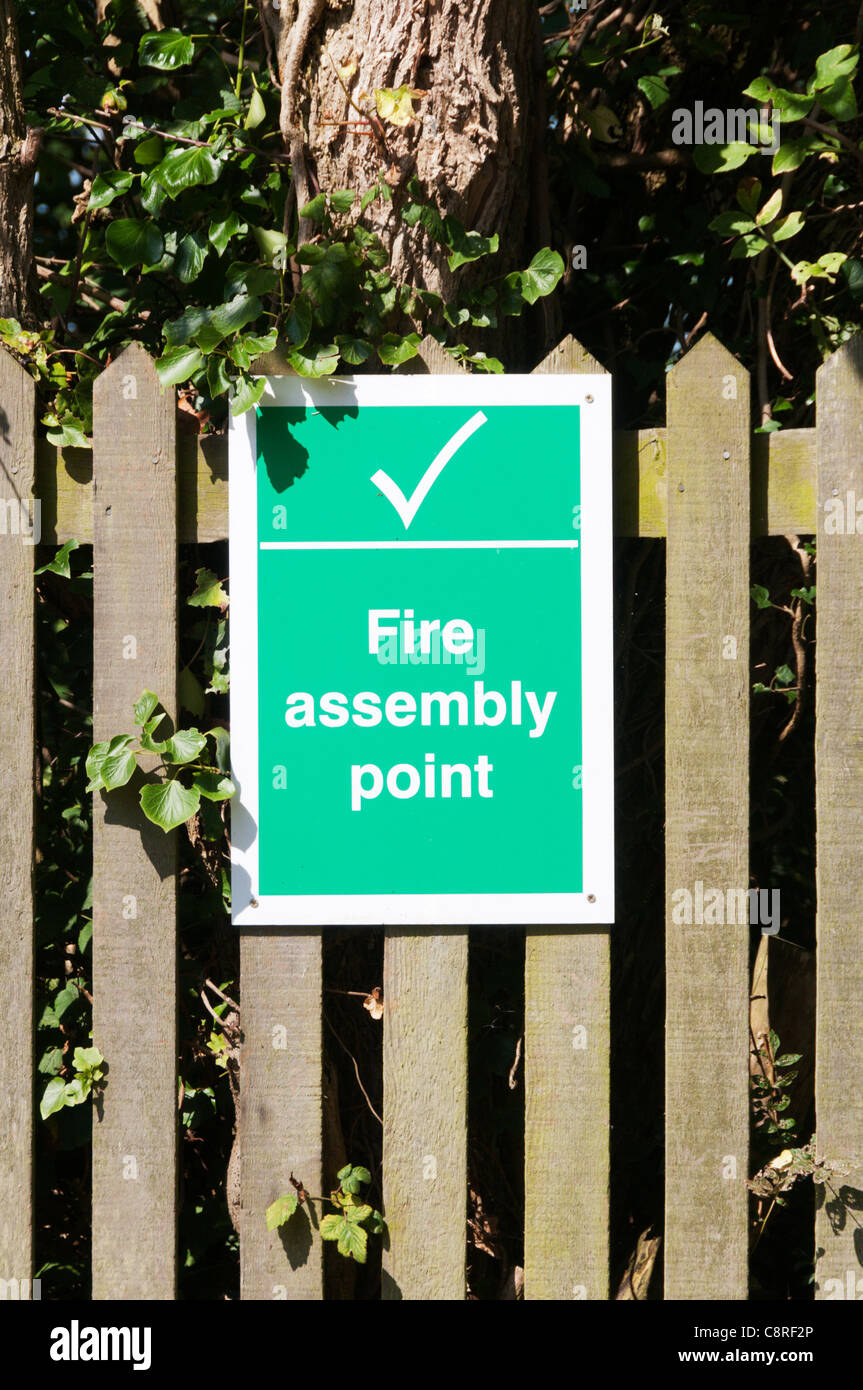 Un segno su una staccionata di legno segna un punto di raccolta in caso di incendio Foto Stock
