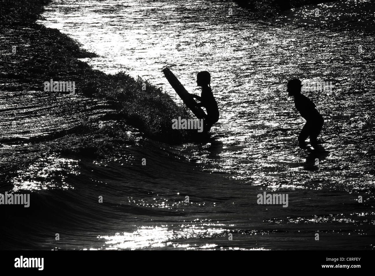 Kids bodyboarding nella luce della sera sulla spiaggia Bondi lifestyle. Australia Foto Stock