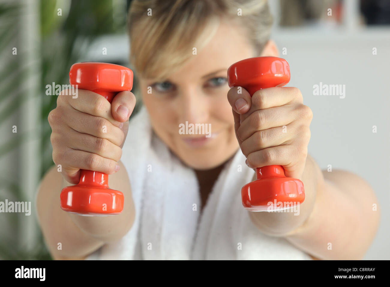 Donna sollevamento pesi nella palestra Foto Stock