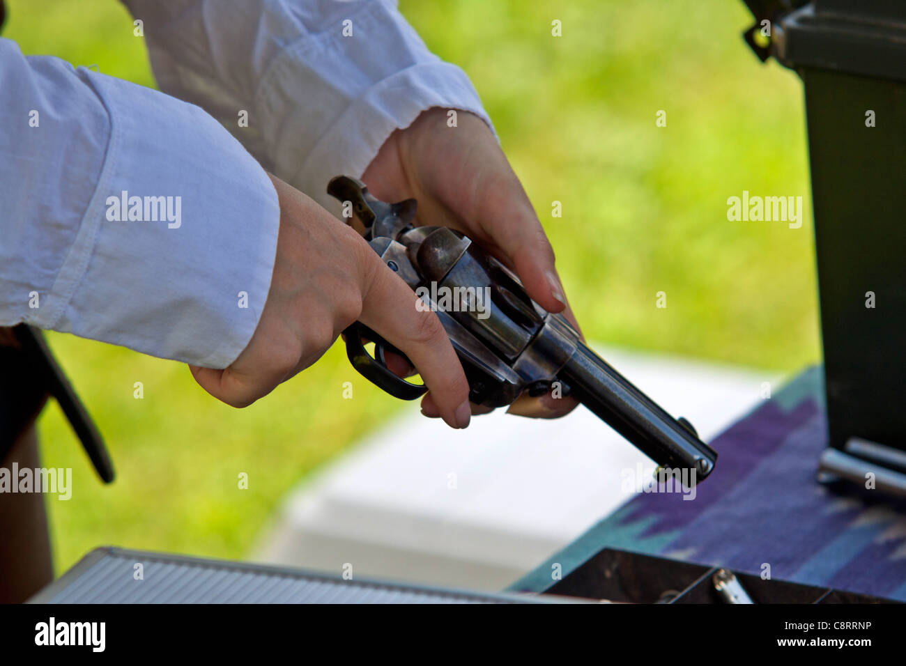 Donna caricamento di un calibro 45 unica azione revolver per un cowboy montato gara di tiro Foto Stock