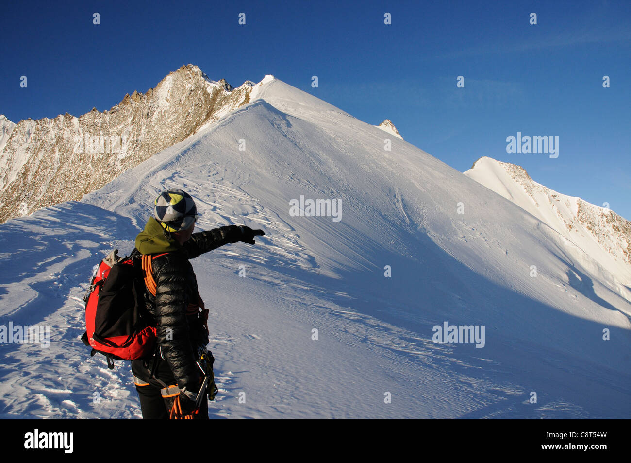 Una guida di montagna indicando la via alta nelle Alpi Svizzere Foto Stock