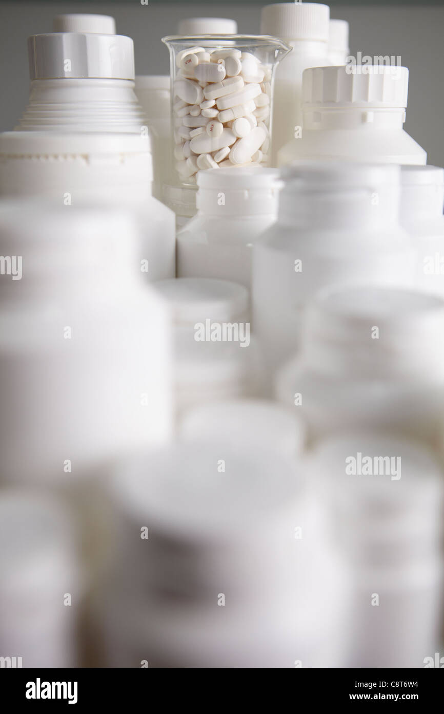 Close-up di pillola bottiglie lungo con bicchiere riempito con le pillole Foto Stock