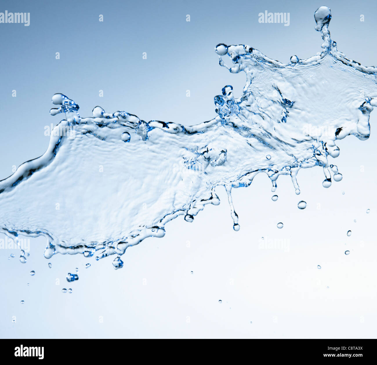 Studio shot di acqua splash su sfondo blu Foto Stock