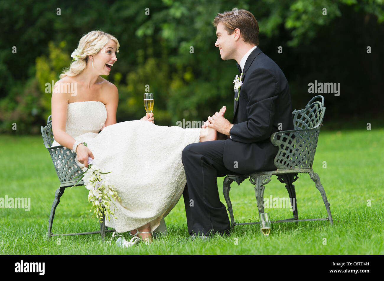 Stati Uniti d'America, nello Stato di New York, Old Westbury, coppia di novelli sposi seduti, sposo sposa di massaggio ai piedi dell Foto Stock