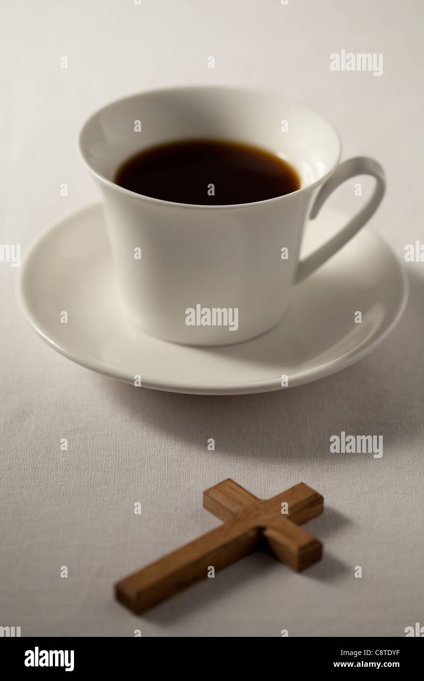 Tazza di tè nero con forma a croce in background Foto Stock