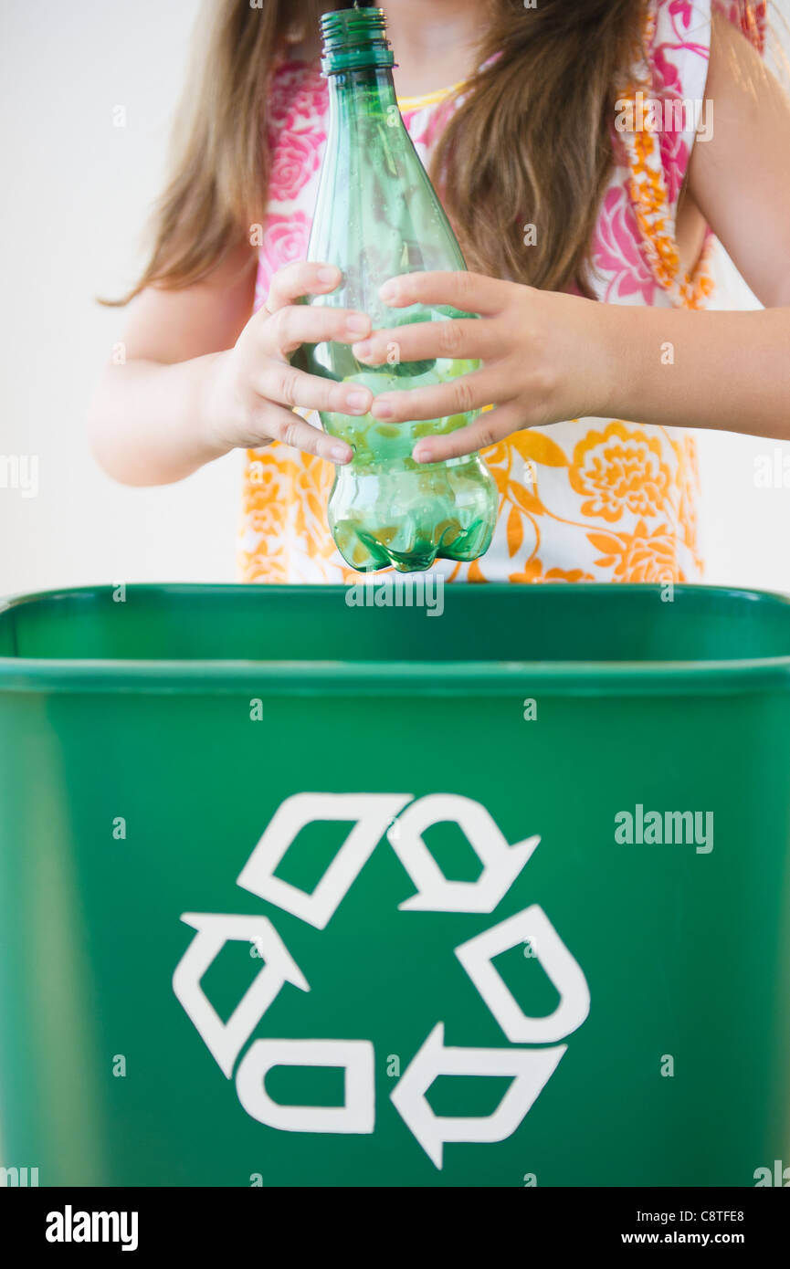 Stati Uniti d'America, New Jersey, Jersey City, Close up della ragazza di gettare la bottiglia di plastica per il contenitore di riciclaggio Foto Stock