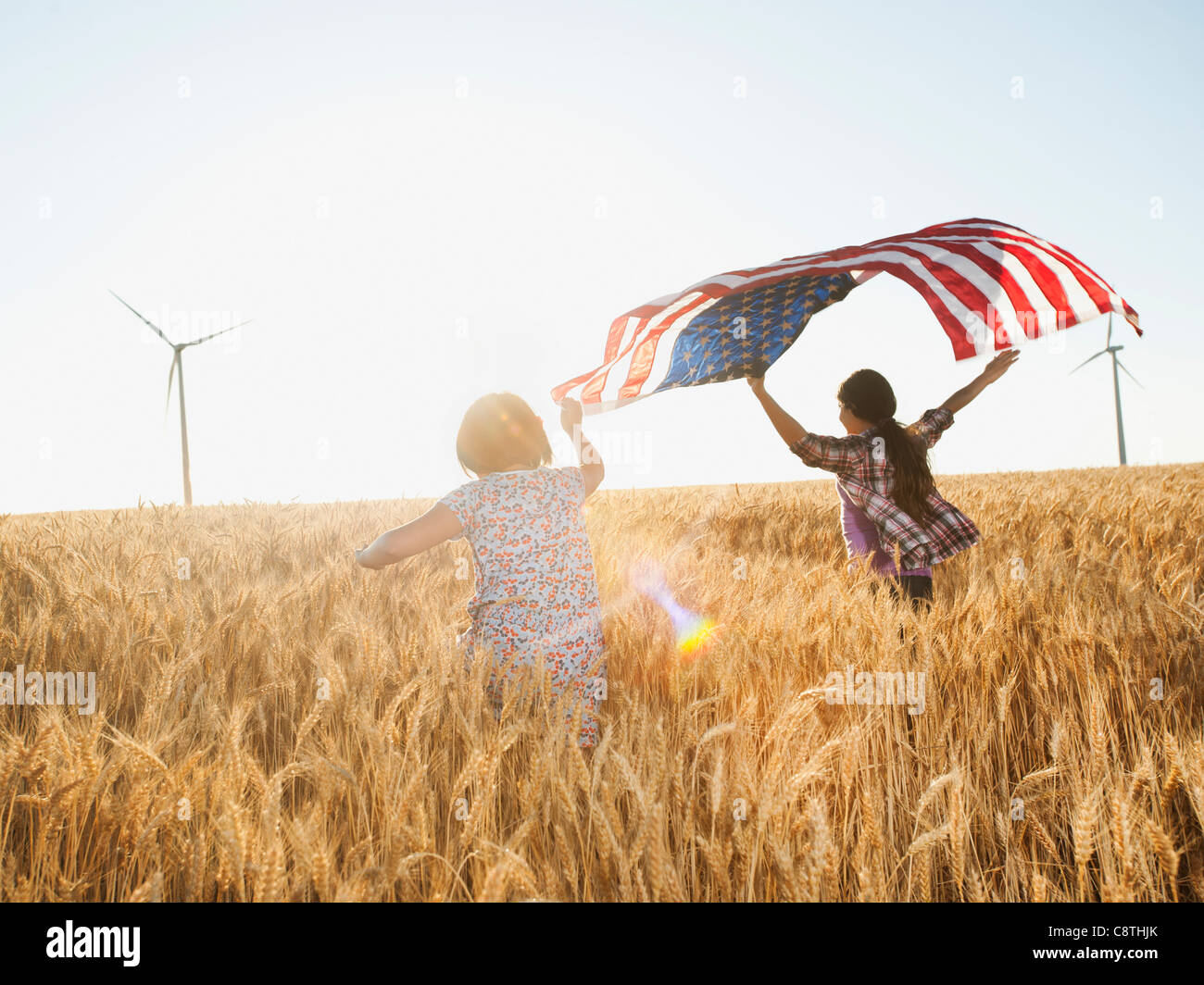 Stati Uniti d'America, Oregon, Wasco, ragazze battenti bandiera americana nel campo di grano Foto Stock