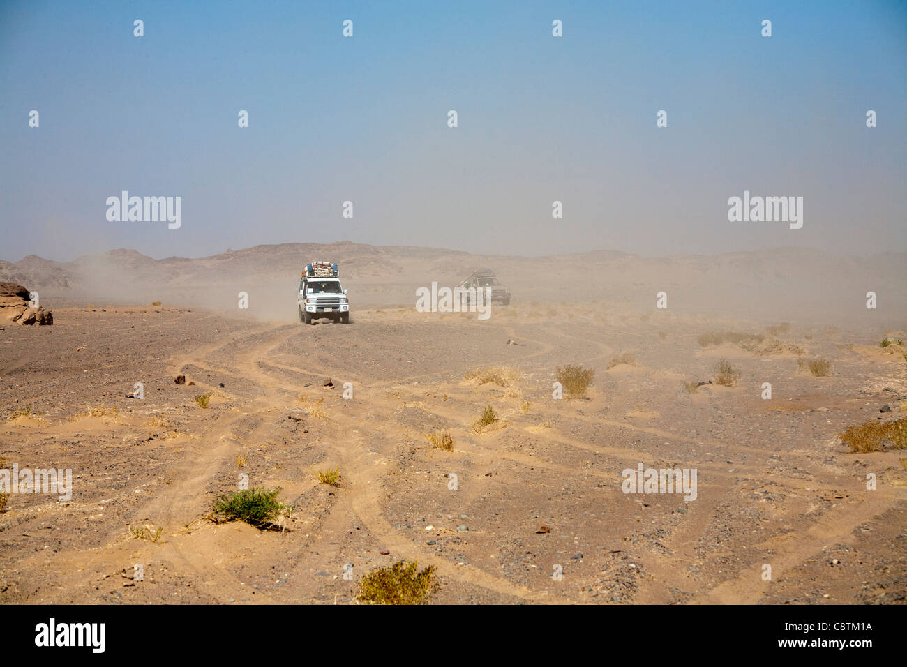 Colpo lungo di quattro ruote motrici avvicinando la fotocamera calci su sentieri di polvere in Egitto e nel deserto orientale Foto Stock