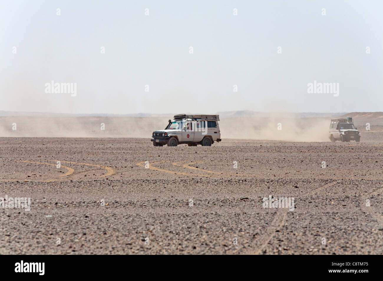 Colpo lungo di quattro ruote motrici avvicinando la fotocamera calci su sentieri di polvere in Egitto e nel deserto orientale Foto Stock