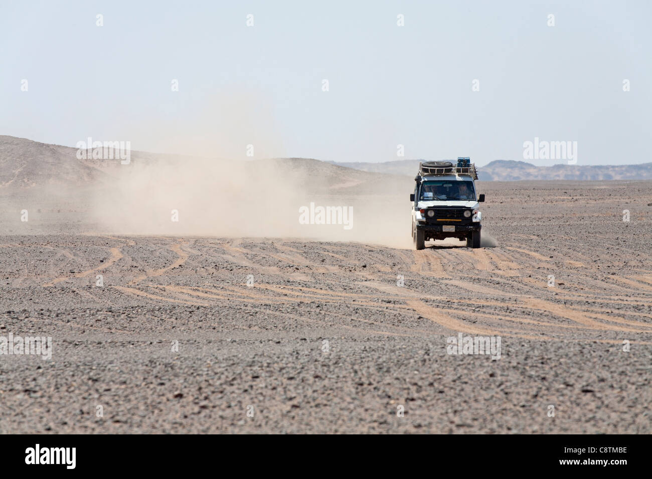 Colpo lungo di quattro ruote motrici avvicinando la fotocamera calci su sentieri di polvere in Egitto e nel deserto orientale Foto Stock