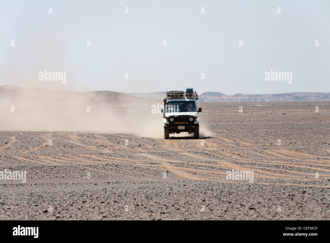 Colpo lungo di quattro ruote motrici avvicinando la fotocamera calci su sentieri di polvere in Egitto e nel deserto orientale Foto Stock