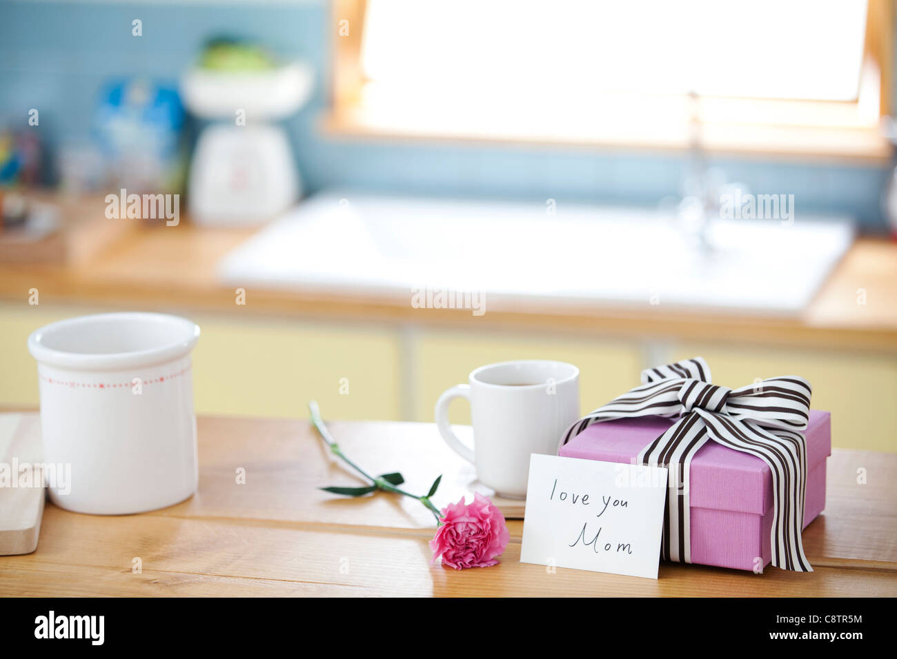 Avvolto confezione regalo e una tazza da caffè sul bancone della cucina Foto Stock