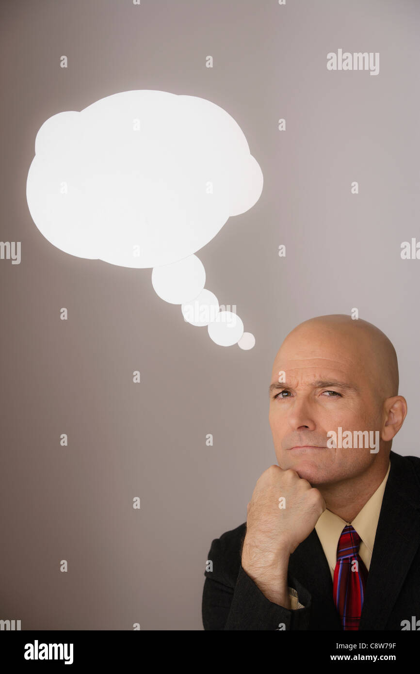 Studio shot di pensieroso uomo d affari con discorso bolla sopra la testa Foto Stock
