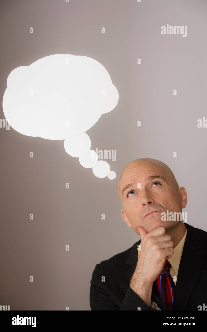 Studio shot di pensieroso uomo d affari con discorso bolla sopra la testa Foto Stock