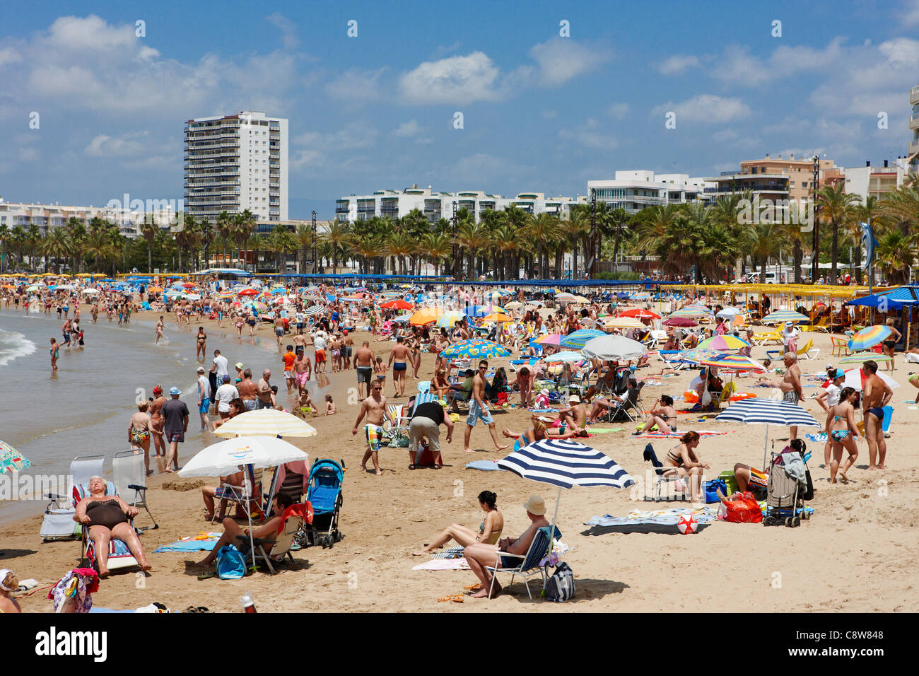 Persone prendere il sole sulla affollata spiaggia di Llevant a Salou, Catalogna, Spagna. Foto Stock