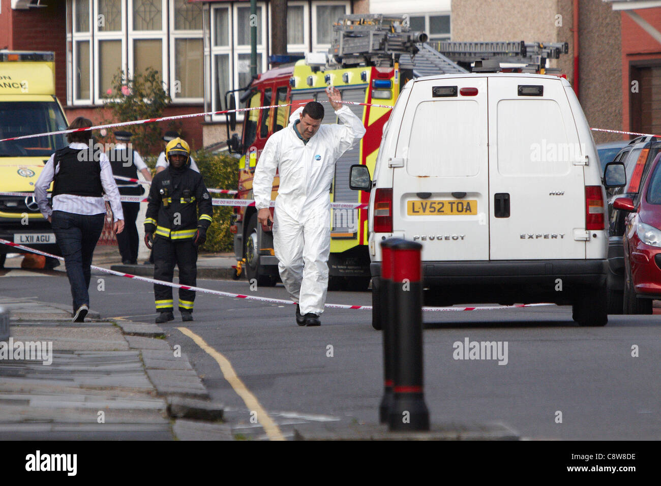 Forensics officer presso la scena di una casa di fuoco a Neasden, a nord di Londra, che è costato la vita di 6 membri della stessa famiglia Foto Stock