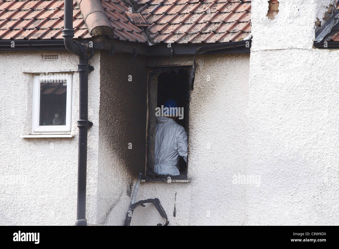 Forensics officer presso la scena di una casa di fuoco a Neasden, a nord di Londra, che è costato la vita di 6 membri della stessa famiglia Foto Stock