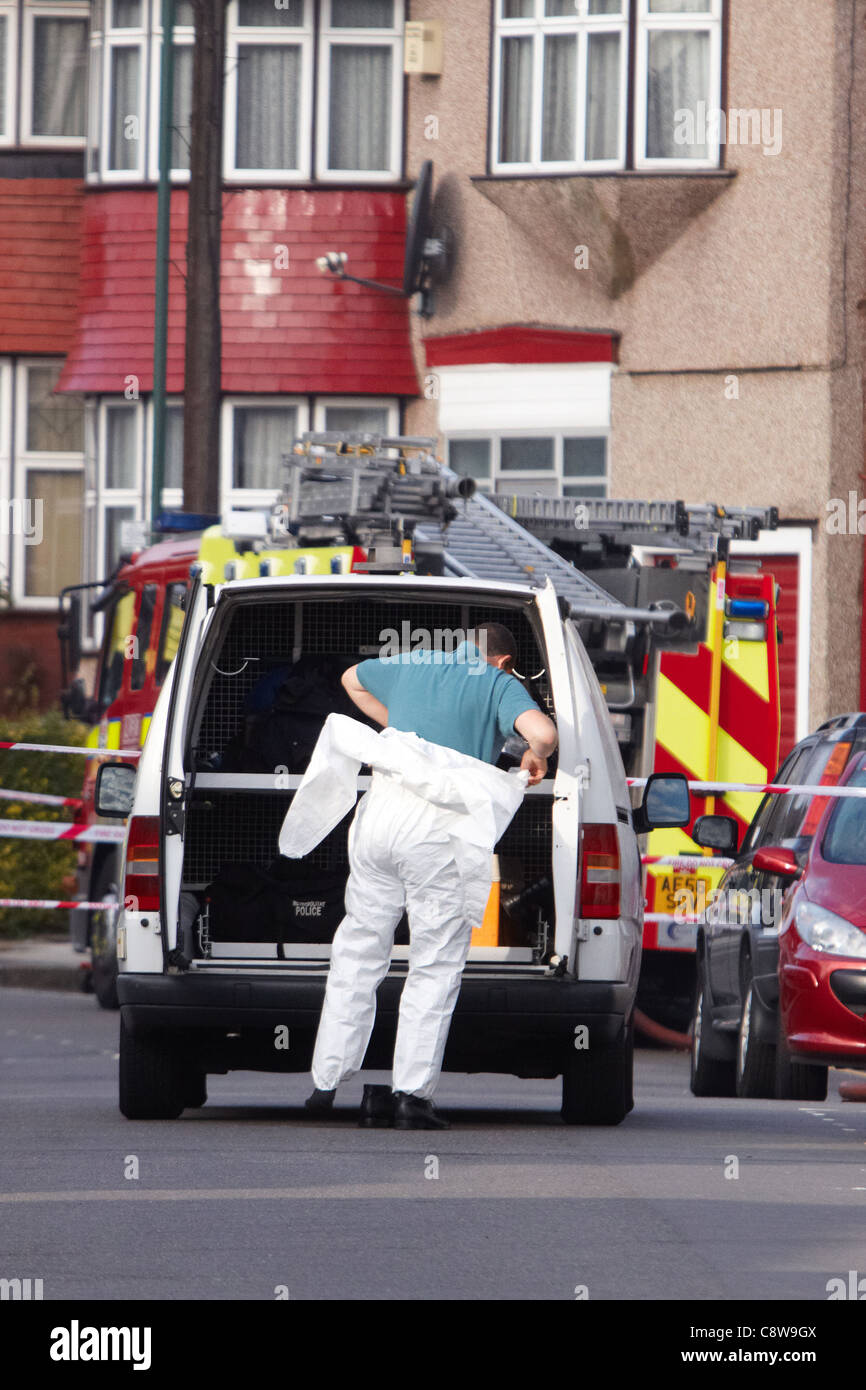 Forensics officer presso la scena di una casa di fuoco a Neasden, a nord di Londra, che è costato la vita di 6 membri della stessa famiglia Foto Stock