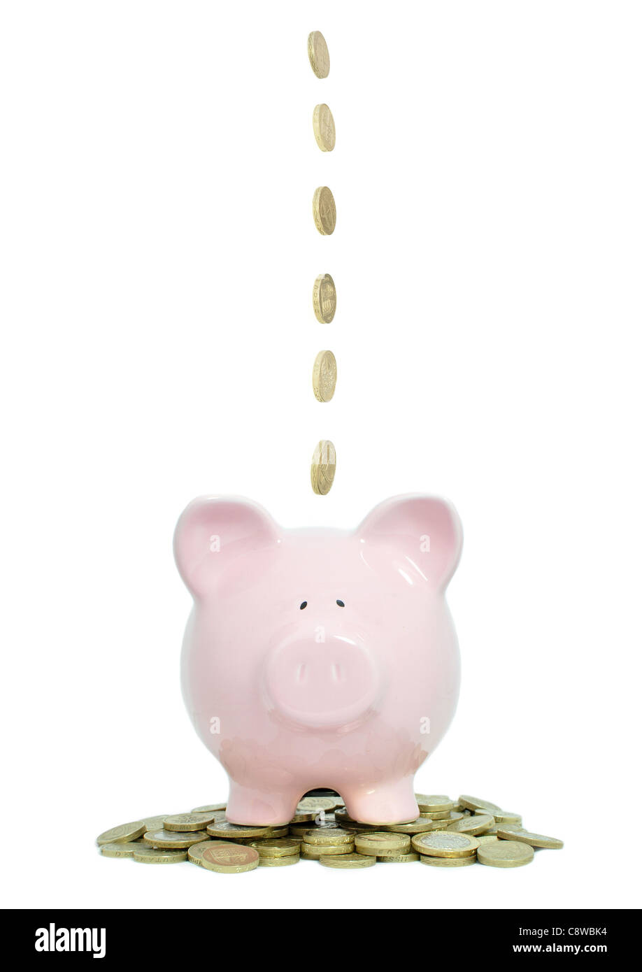 Monete di cadere in un piggybank Foto Stock