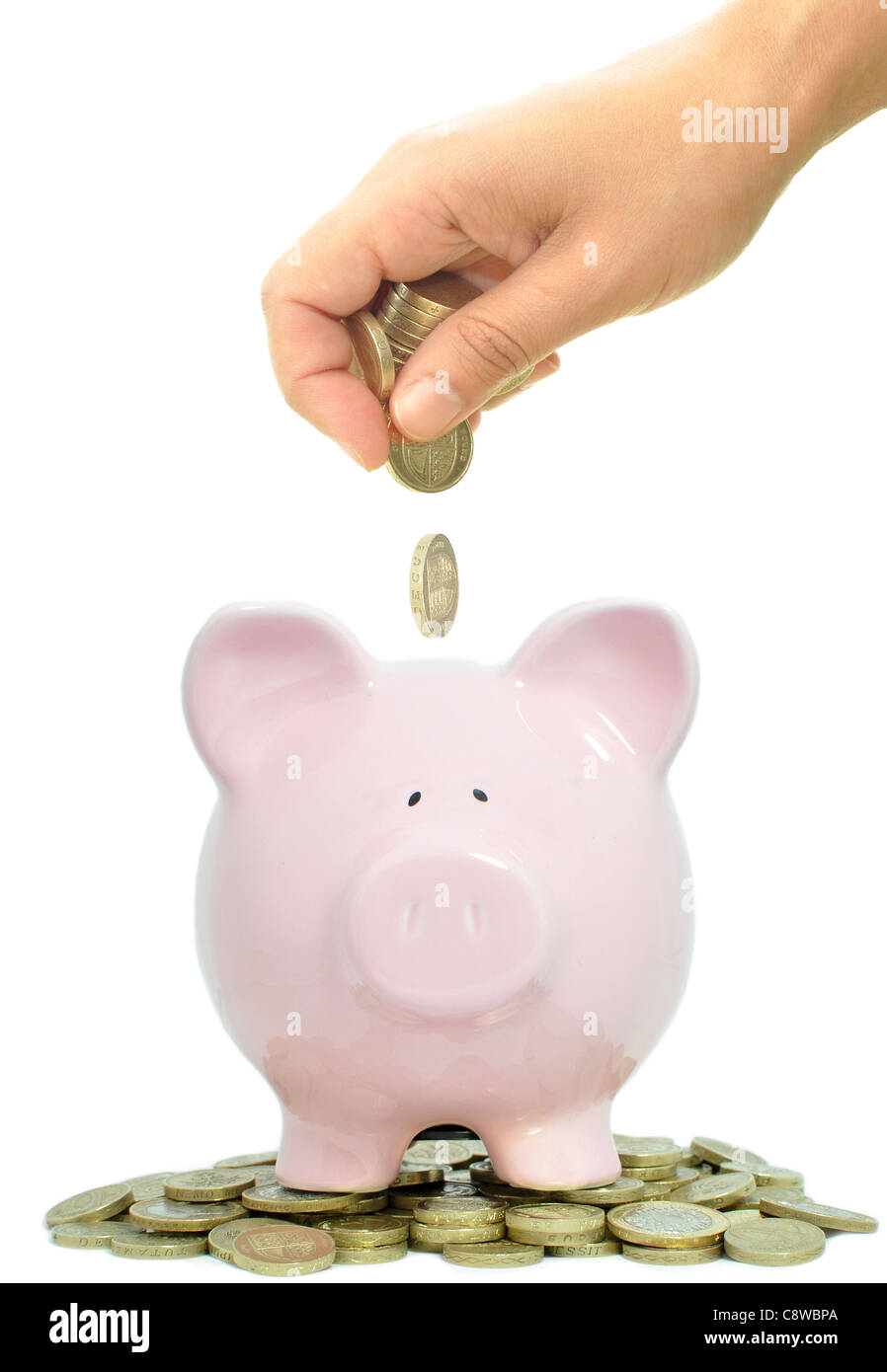 Piggybank essendo riempito con le monete Foto Stock