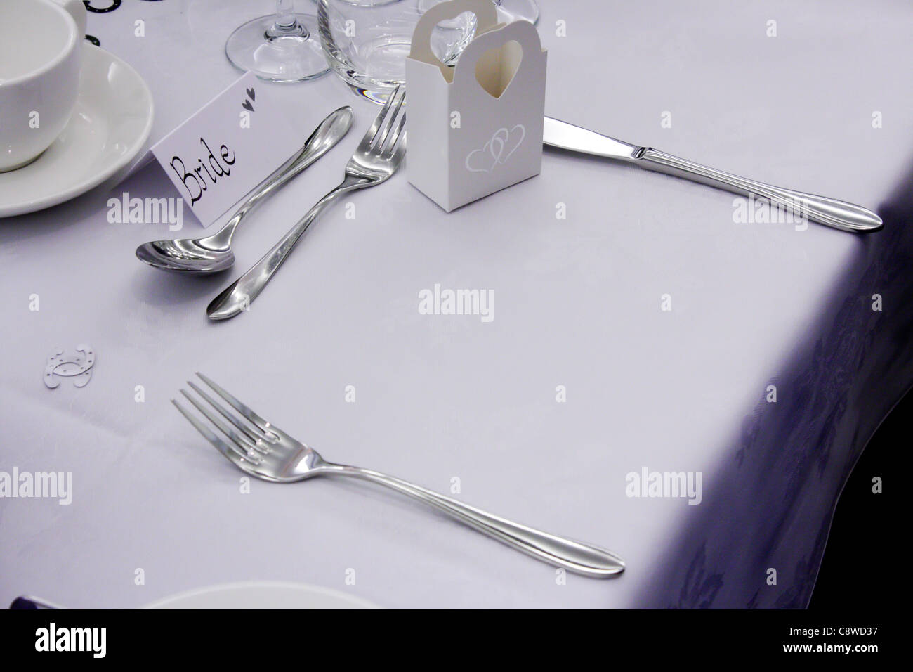 La sposa e lo Sposo le regolazioni del posto e i loro ospiti a capo tavola superiore il giorno delle nozze, tutti i vuoti, impostato e pronto. Foto Stock