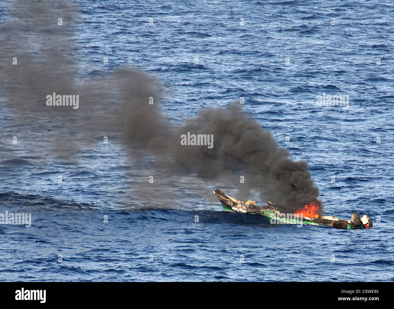 Un sospetto pirate skiff burns dopo essere stato distrutto dal dock anfibio sbarco nave USS Ashland Foto Stock