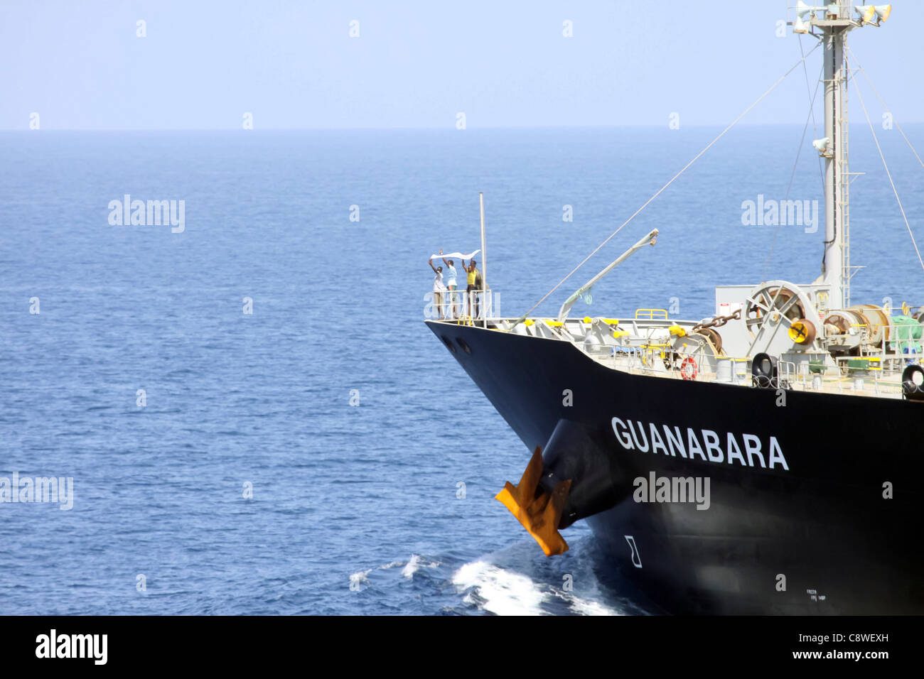 Sospetti pirati indicano la loro resa con un panno bianco sulla prua del giapponese-commerciali di proprietà petroliera M/V Guanabara. Il guidato-missile destroyer USS Bulkeley (DDG 84), con il sostegno della Marina turca fregata Giresun TCG (F 491), assigne Foto Stock