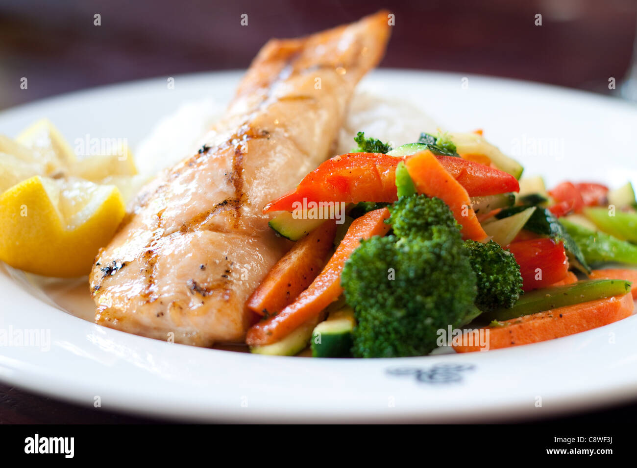 Filetto di salmone al forno con il nostro smalto di acero, servito su un letto di aromatico riso basmati con STIR FRY di verdure. Foto Stock