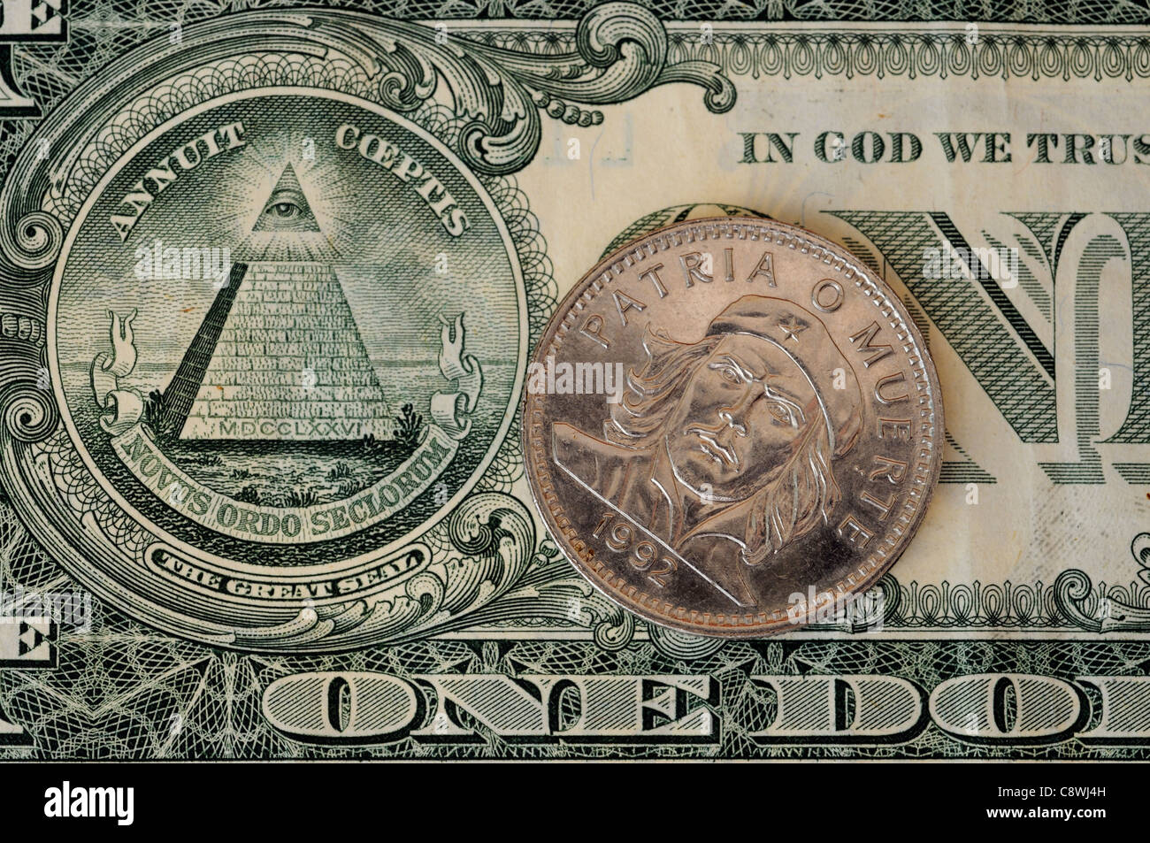 Un cubano di moneta con un ritratto di Che Guevara e di una piramide sul dollaro americano Bill Foto Stock