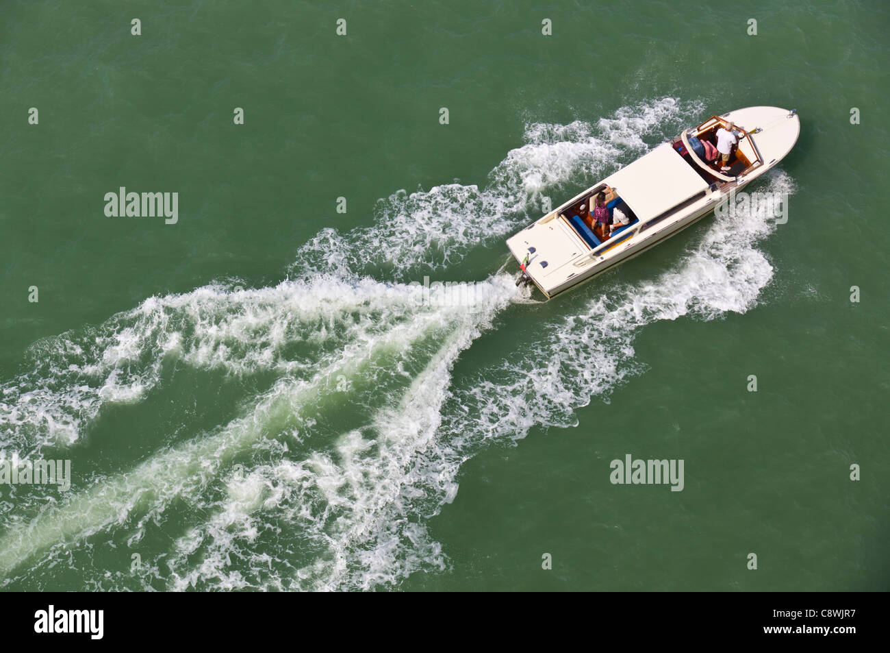 Venezia - La piccola barca su acque Guidecca che mostra il modello della barca wake nel verde acqua. Foto Stock