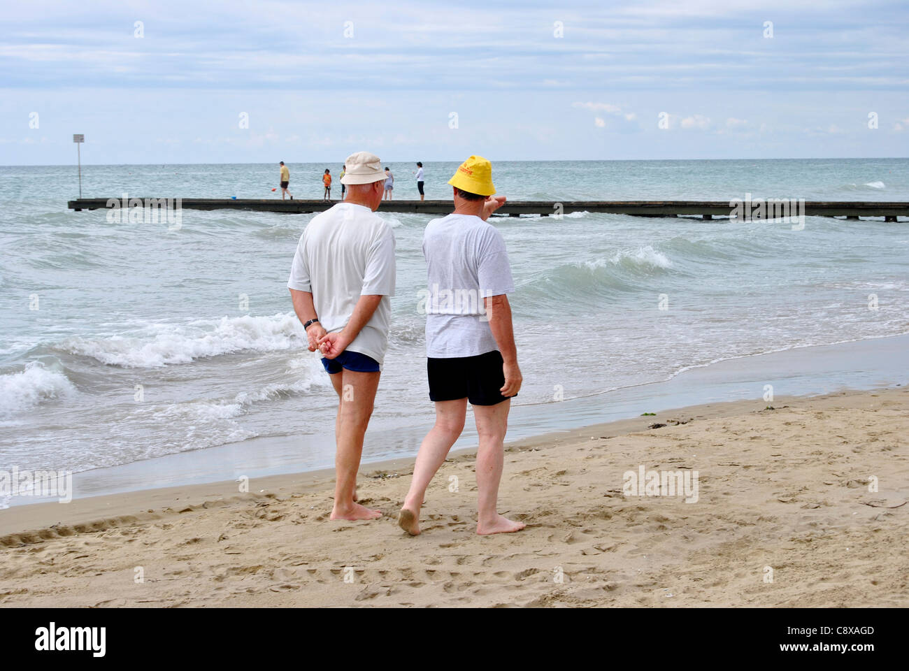 Felice coppia senior fate una passeggiata su una bellissima spiaggia italyl. Foto Stock