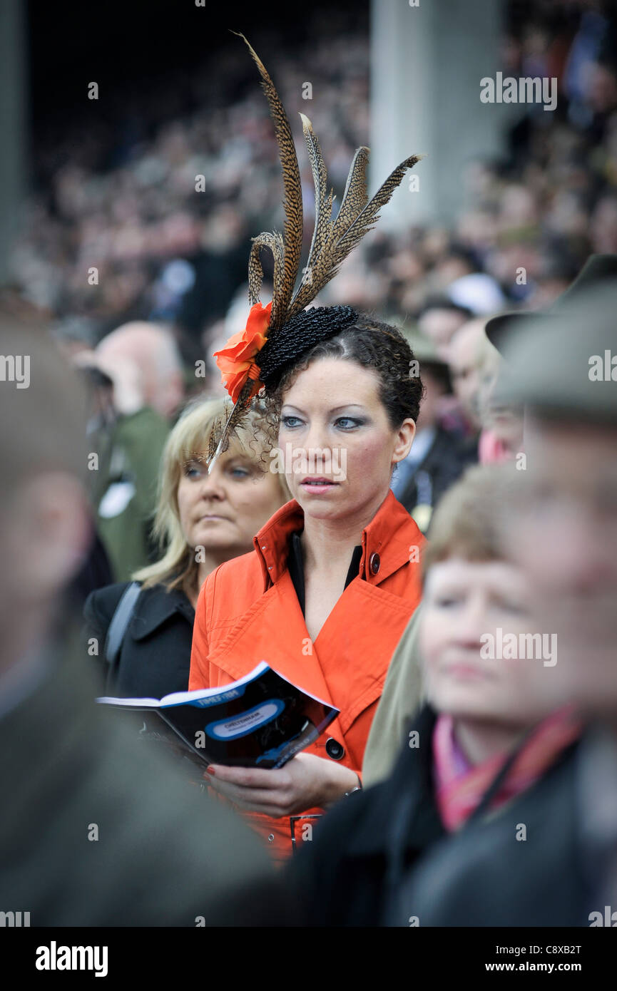 Donna che indossa un cappello con piume a Cheltenham Horse Racing Foto Stock
