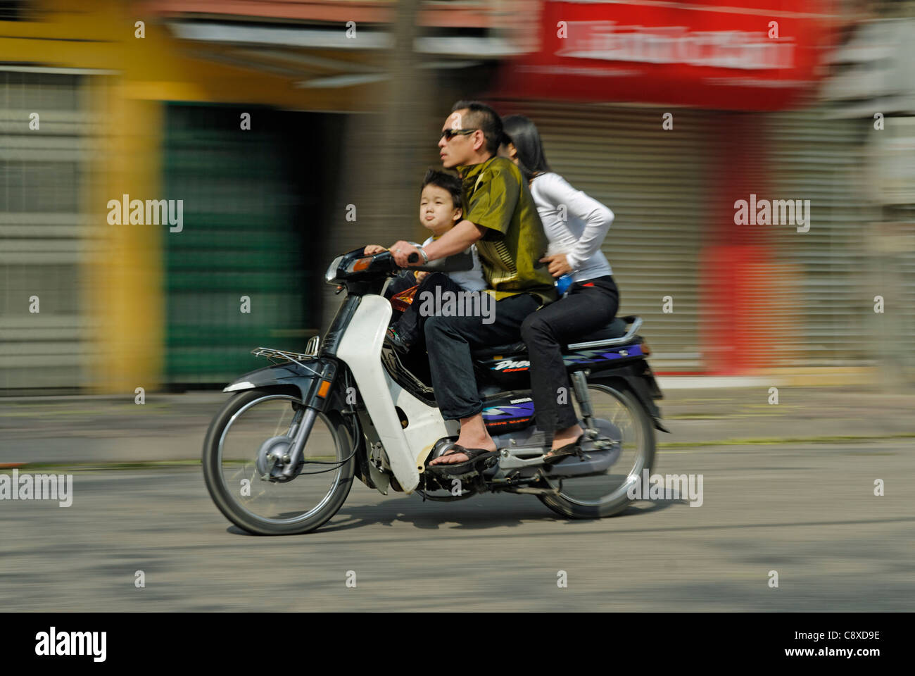 Asia Vietnam Hanoi. Hanoi old quarter. Famiglia sulla moto correre attraverso Hanoi.... Foto Stock
