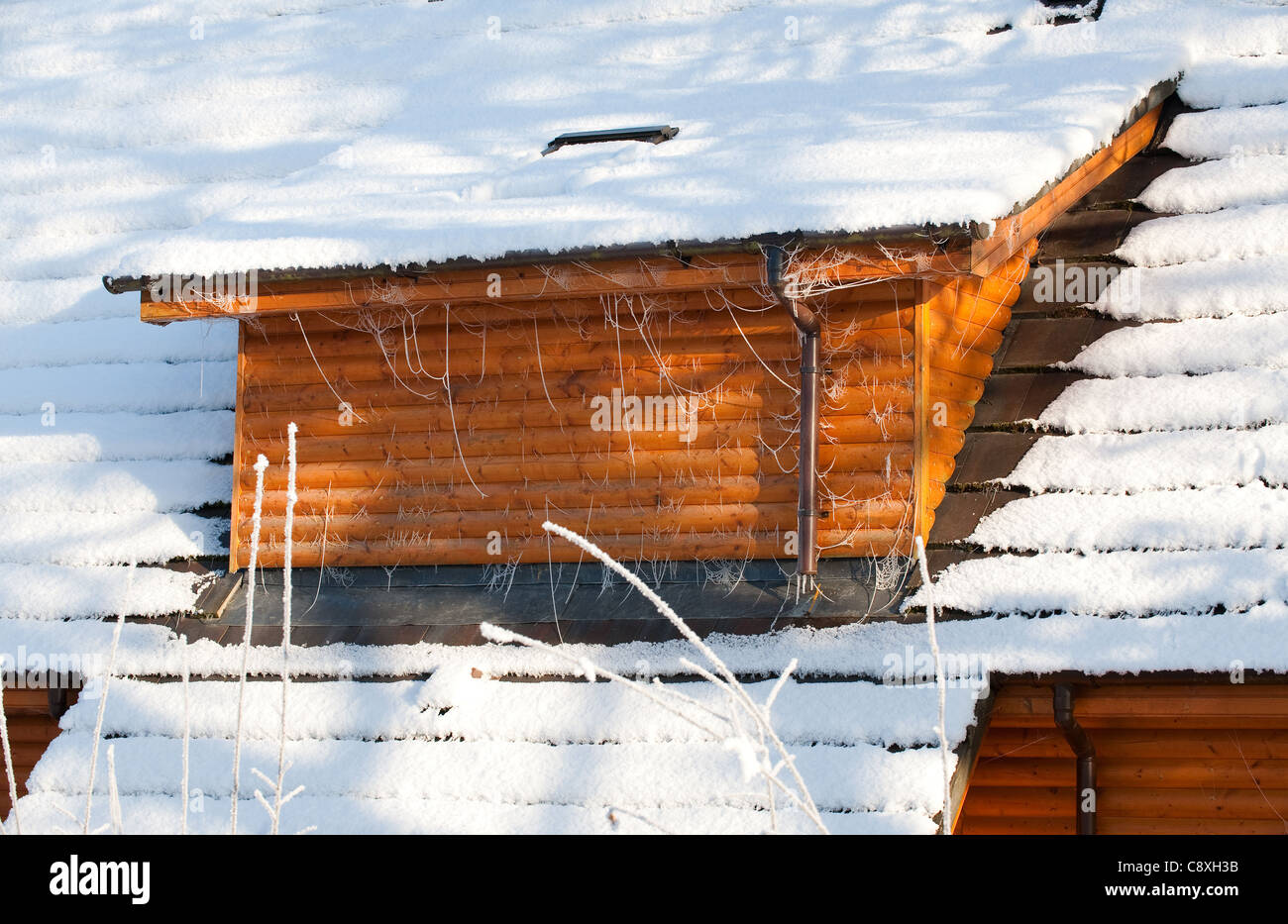 Vista sulla casa in legno il tetto coperto di neve Foto Stock