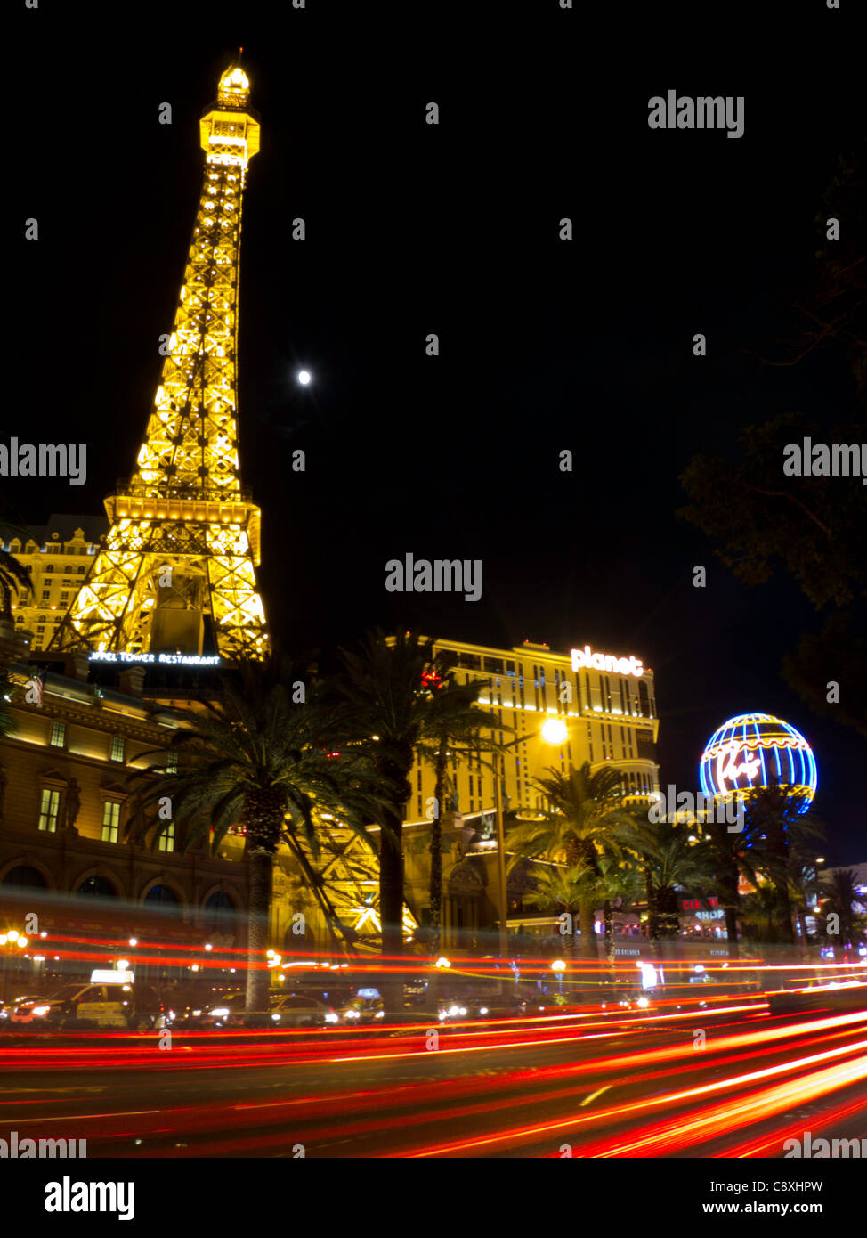 I flussi di traffico lungo la striscia di notte accanto al casinò di Parigi e la Torre Eiffel, Las Vegas, Nevada Foto Stock