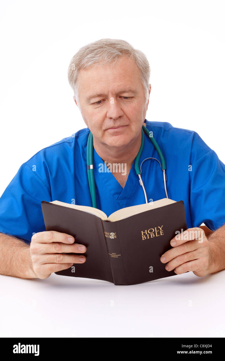 Chirurgo uomo della lettura della Bibbia in pausa di lavoro Foto Stock