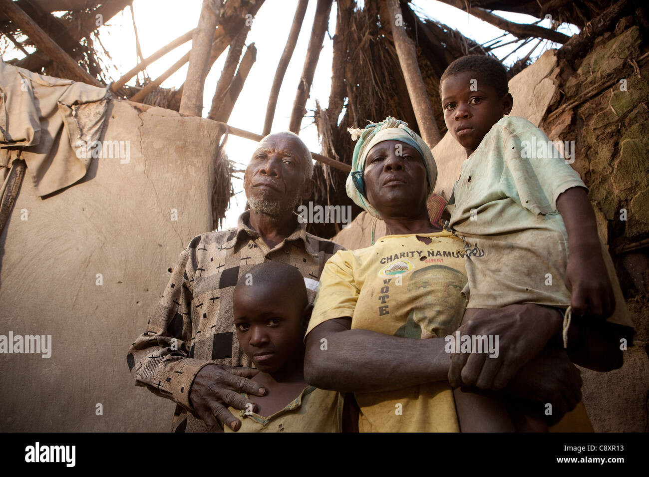 Una famiglia sta nella loro casa danneggiata nel quartiere Namutumba, Uganda, a seguito di forti grandinate. Foto Stock